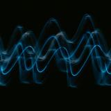 Blaue Lichtwellen vor schwarzem Hintergrund (Foto: unsplash)