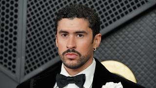 Bad Bunny steht im schwarzen Anzug vor einem dunklen Hintergrund. (Foto: DPA / Picture Alliance)