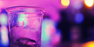 Ein Plastikbecher vor verschwommenen Partyslichtern. (Foto: pixabay/Laura Jimenez)