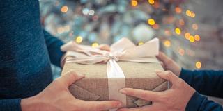 Jemand überreicht ein Geschenk an jemand anderes (Foto: pixabay / Bob_Dmyt)