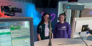 Zwei Mädchen stehen im UNSERDING-Studio hintem Mikrofon. (Foto: UNSERDING)