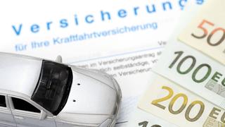 Kfz-Versicherungsschein und Miniaturauto, Symbolbild für  Kfz-Versicherungsbeiträge (Foto: IMAGO / imagebroker)