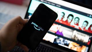 Ein Handy zeigt den Schriftzug amazon prime. Dahinter ist verschwommen die Filmübersicht von amazon prime zu sehen. (Foto: IMAGO / Hans Lucas)