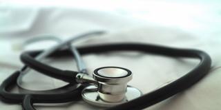 Ein Stethoskop auf einem Arztkittel (Foto: IMAGO / Design Pics)