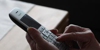 Eine ältere Person hält einen Telefonhörer in der Hand. (Foto: Imago/Fleig/Eibner-Pressefoto)