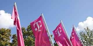 Werbefahnen der Telekom wehen im Wind (Foto: IMAGO / wolterfoto)
