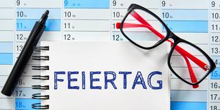 Symbolbild Feiertage. Schriftzug auf einem Notizbuch auf einem Kalender. (Foto: IMAGO / Bihlmayerfotografie)