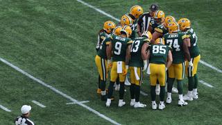Ein Team aus Football-Playern steht im Kreis zusammen.  (Foto: IMAGO / Action Plus)