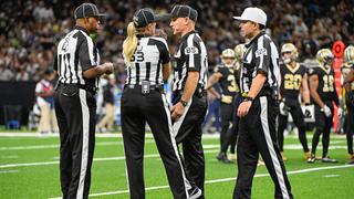 Vier Schiedsrichter stehen in schwarz-weißen Uniformen auf dem Football-Feld und beraten sich. (Foto: IMAGO / Icon Sportswire)
