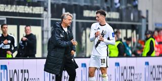 Horst Steffen und Fisnik Asllani stehen auf dem Rasen und sprechen miteinander. (Foto: IMAGO / DeFodi)