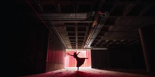 Tänzerin in abgedunkelter Halle (Foto: IMAGO / Addictive Stock)
