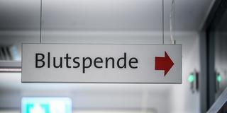 Ein Schild mit der Aufschrift Blutspende hängt in einem Gang. (Foto: IMAGO / Funke Foto Services / Kerstin Kokoska)