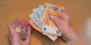 Eine alte Frau zählt Geld. (Foto: IMAGO / Schöning)