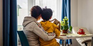 Eine Bewohnerin mit ihrem Sohn auf dem Schoß in einem Frauenhaus (Foto: IMAGO / Funke Foto Services)