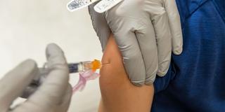 Eine Pflegende Person impft ein Kind (Foto: IMAGO / Pond5 Images)