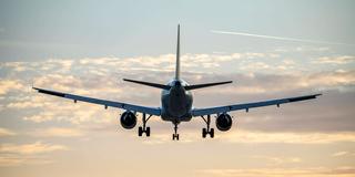 Flugzeug schwebt knapp über der Landbahn vor sonnengefärbtem Himmel (Foto: IMAGO / Jochen Tack)