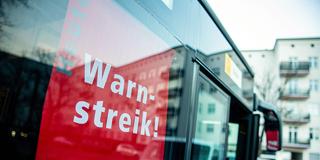 Ein Schild in einem Bus weist auf einen Warnstreik im Nahverkehr hin (Foto: IMAGO / Manngold)