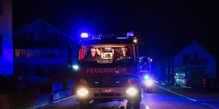 Feuerwehr-Fahrzeuge mit Blaulicht bei Nacht (Symbolbild) (Foto: IMAGO / Jan Huebner)