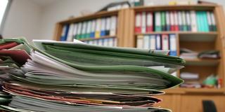 Aktenberg auf einem Schreibtisch im Büro (Foto: IMAGO / blickwinkel)