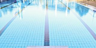 Ein Gesperrerter Startblock in einem menschenlehren Freibad (Foto: IMAGO / Westend61)