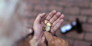 Ein Rentner zählt sein Kleingeld am Eingang zu einem Einkaufsmarkt. (Foto: Imago Images/Future Image)