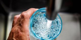 Jemand füllt ein Glas am Wasserhahn (Foto: IMAGO / ANP)