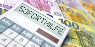 Symbolbild. Corona-Soforthilfe. Taschenrechner mit Eurobanknoten (Foto: IMAGO / imagebroker)