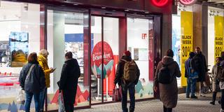 Passanten und Kunden vor dem Schaufenstern einer Ladenzeile (Foto: IMAGO / Ardan Fuessmann)