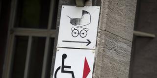 Schild weist auf den barrierefreien Eingang fuer Rollstuhlfahrer und Kinderwagen hin (Foto: IMAGO / photothek)