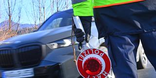 Grenzkontrolle der Polizei. Beamter mit einer Polizeikelle steht neben einem Fahrzeug. (Foto: IMAGO / Sven Simon)