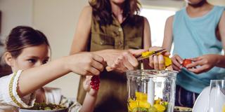 Eine Familie bereitet Obst in der Küche zu (Foto: IMAGO / Westend61)