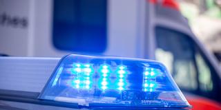 Nahaufnahme von blinkendem Blaulicht bei einem Polizeieinsatz mit Rettungswagen im Hintergrund     (Foto: IMAGO / Herrmann Agenturfotografie    )