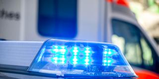 Blaulicht eines Polizeiwagen vor einem Fahrzeug des Rettungsdienstes (Foto: IMAGO / Herrmann Agenturfotografie)