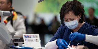 Zahnärztin bei der Behandlung einer Patientin. (Foto: IMAGO / Political-Moments)