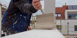 Ein Maurer arbeitet auf einer Baustelle (Foto: IMAGO / Herrmann Agenturfotografie)