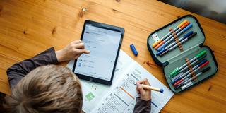 Ein Schüler lernt mit Tablet und Arbeitsheft (Foto: IMAGO / photothek)