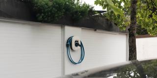 Wallbox Ladestation an Garage mit einem parkendem Auto davor  (Foto: IMAGO / S. Gottschalk)