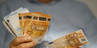 Eine Person hält Euroscheine in der Hand (Foto: IMAGO / Westend61)