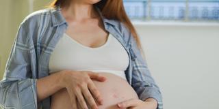 Eine Schwangere Frau umarmt ihren Bauch (Foto: IMAGO / Zoonar)