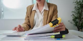 Frau bearbeitet einen Papierstapel am Schreibtisch. (Foto: IMAGO / Zoonar)