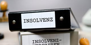 Symbolbild Insolvenz. Insolvenzakten liegen auf dem Tisch. (Foto: IMAGO / Christian Ohde)