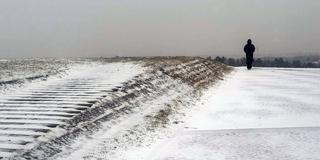Grauer Himmel über leicht mit Schnee bedecktem Boden. (Foto: IMAGO / Sven Simon)