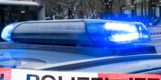 Polizeiabsperrung vor einem Einsatzwagen mit Blaulicht (Foto: IMAGO / teamwork)