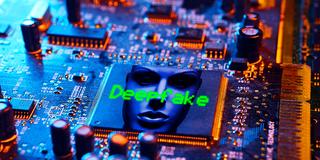 Symbolbild: „Deepfake“ und ein künstlich generiertes Gesicht sind auf eine Computerplatine projeziert (Foto: IMAGO / Christian Ohde)