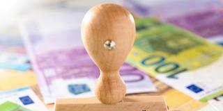 Ein Stempel mit dem Wort "Entlastungsprämie" steht auf Geldscheinen (Foto: IMAGO / Bihlmayerfotografie)