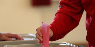 Eine Person wirft ihren Stimmzettel in ein Wahlurne (Foto: IMAGO / Eibner)