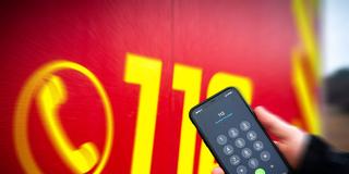 Die Notrufnummer 112 auf einem Smartphone vor einem Feuerwehrwagen (Foto: IMAGO / vmd-images)