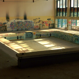 Ein altes Schwimmbecken ohne Wasser. An den Wänden ist jede Menge buntes Graffiti. (Foto: Martin Boosfeld)