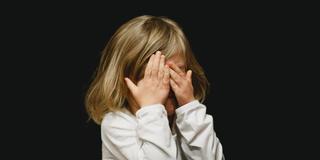 Ein Mädchen schlägt die Hände vor das Gesicht (Foto: unsplash.com)