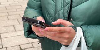 Eine junge Passantin tippt an ihrem Smartphone (Foto: SR)